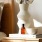 a vase with cotton stems on a bedside table