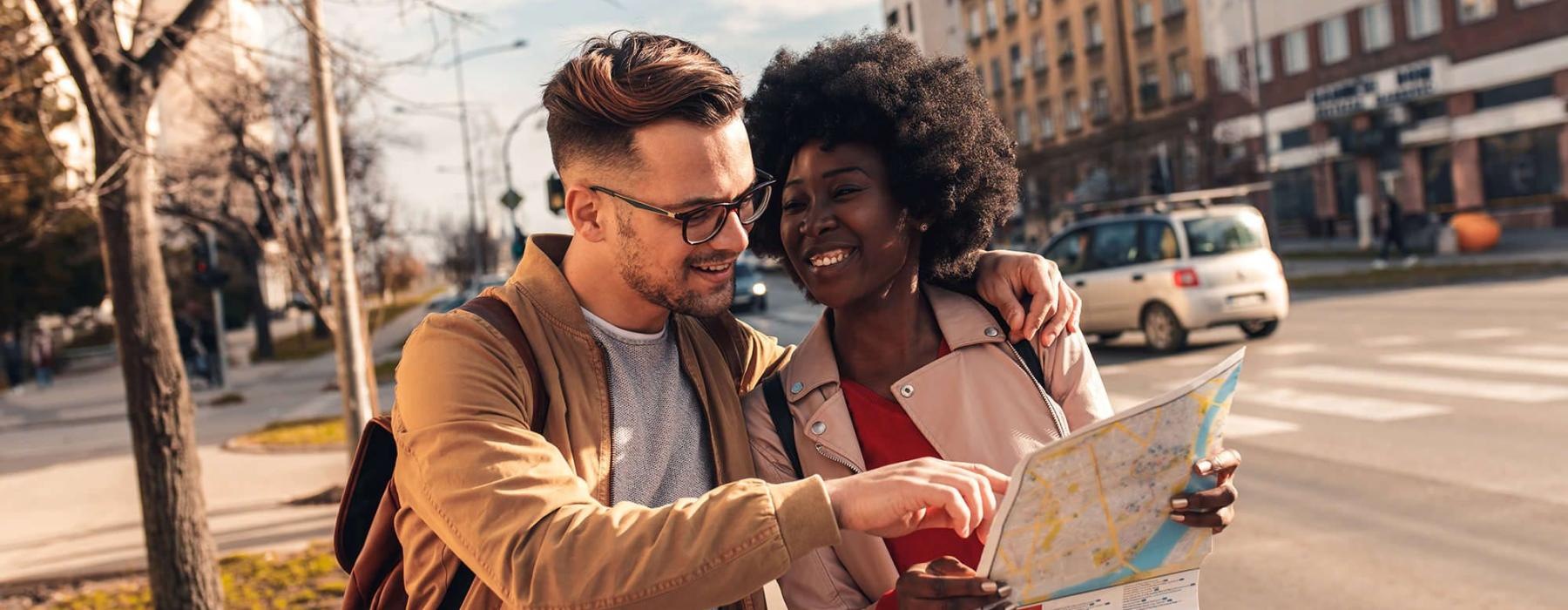 a man and woman looking at a map in the city