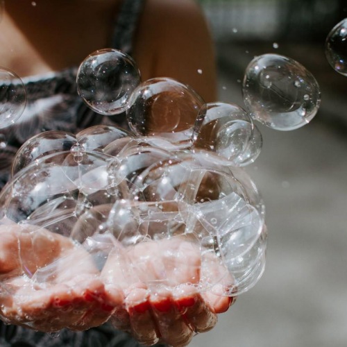 A beautiful community at the heart of all your passions child holding bubbles in her hand as some float away