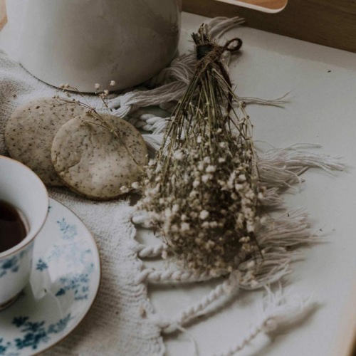 The essence of exceptional living tea and cookies on a serving tray with baby's breath