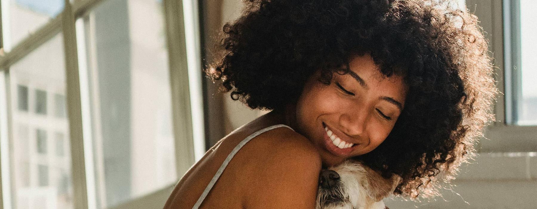 a girl on a bed hugging her dog